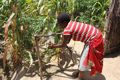 A young woman demonstrates good hand washing technique at a pump activated handwashing station: outside her toilet in Malawi. Globally more than 5.5 million people have heard about the importance of good hygiene through GSF supported community activities. Photograph ©WSSCC/Katherine Anderson